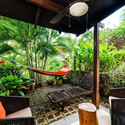 Charming bungalow connected to the third bedroom, featuring a hammock and cozy outdoor seating surrounded by lush Tamarindo gardens.