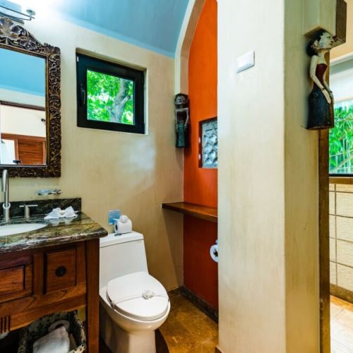 Stylish guest bathroom with colorful Costa Rican-inspired accents and a modern stand-up shower, perfect for a comfortable vacation in Tamarindo.