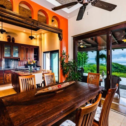 Enjoy group meals around the rustic wooden dining table, showcasing authentic Costa Rica design in this Tamarindo home.